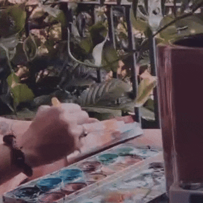 Close up photo of Marianna's hand painting, in film style